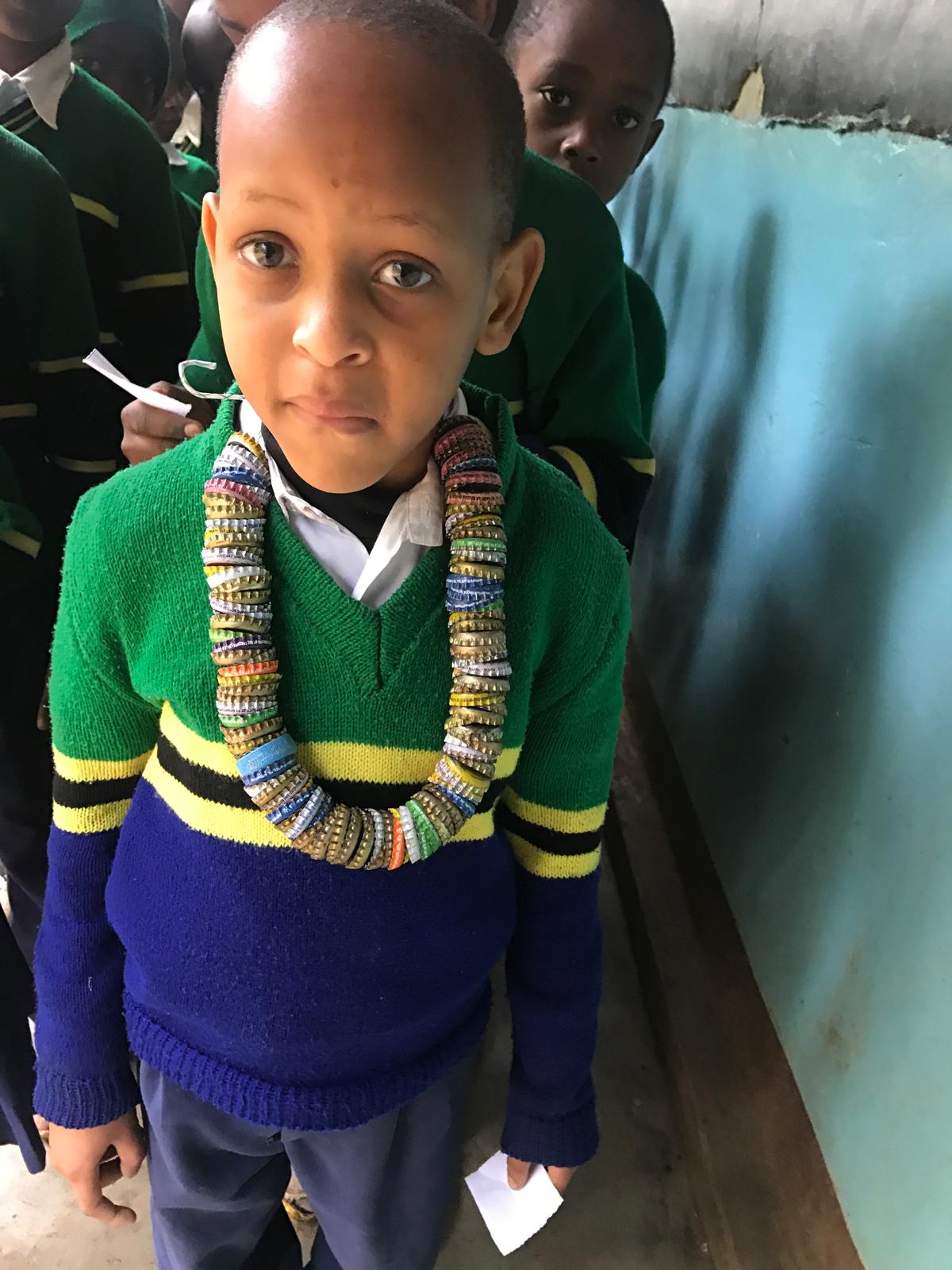 A schoolchild considering a selection of eyeglass frames during an outreach visit