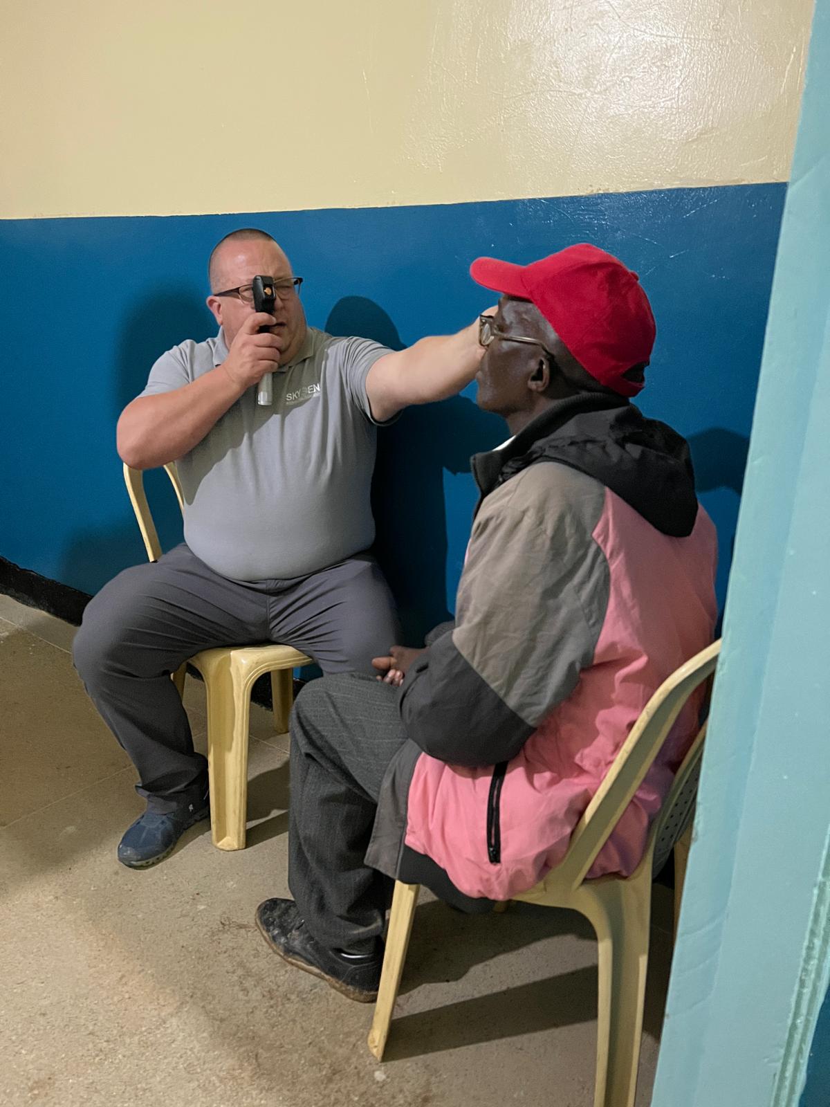 An older adult taking part in a handheld vision screening with a trained team member